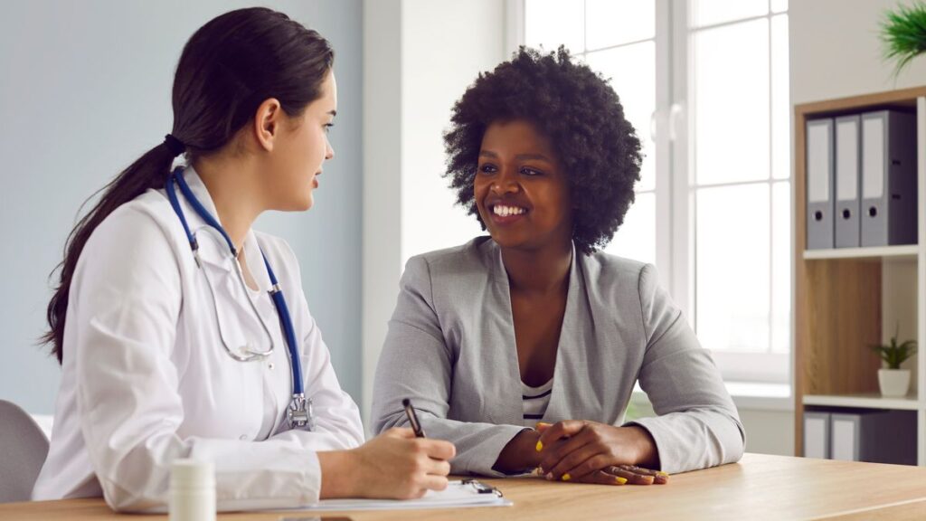 Doctor talking with a smiling patient during a first chiropractic visit