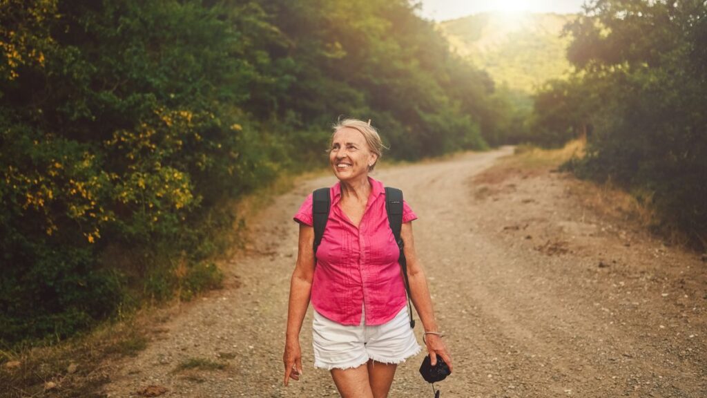 Smiling woman hiking a trail after sciatica relief