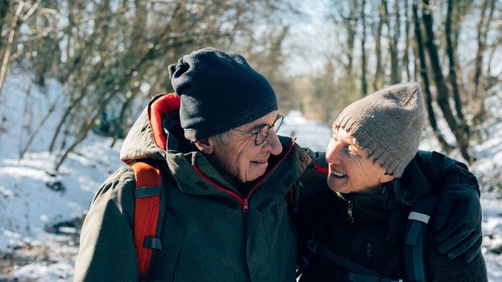 Happy couple walking safely on a snowy winter path